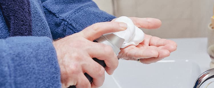 Man spraying shaving cream into his hand.