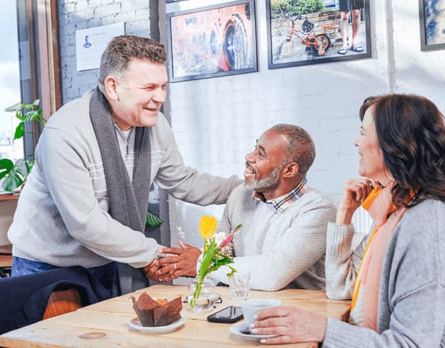 Three people talking in a restaurant.